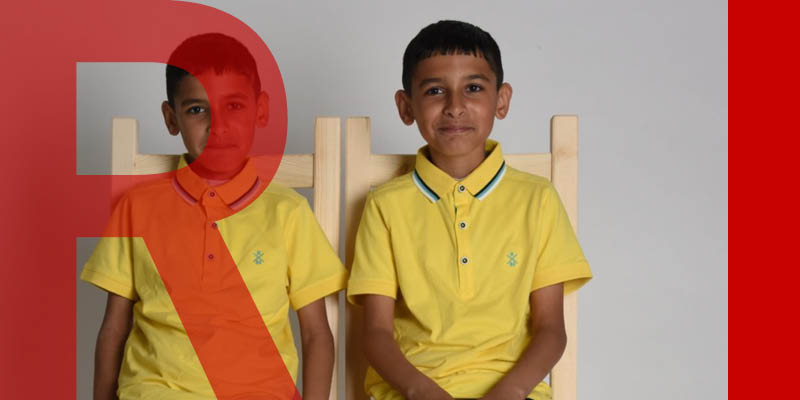 Two children sitting on chairs and smiling