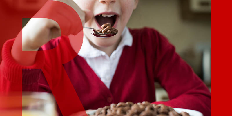 A child in school uniform eating cereal