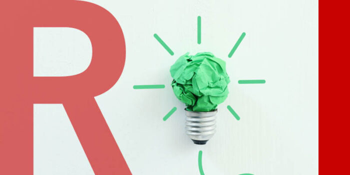 A scrunched up ball of green paper with a lightbulb socket underneath it.
