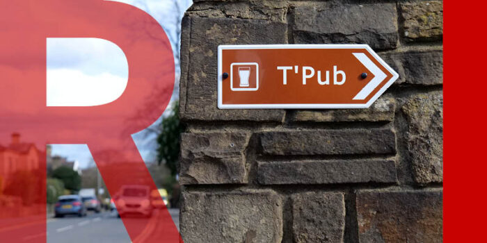 A wall with a sign that reads "T'Pub"