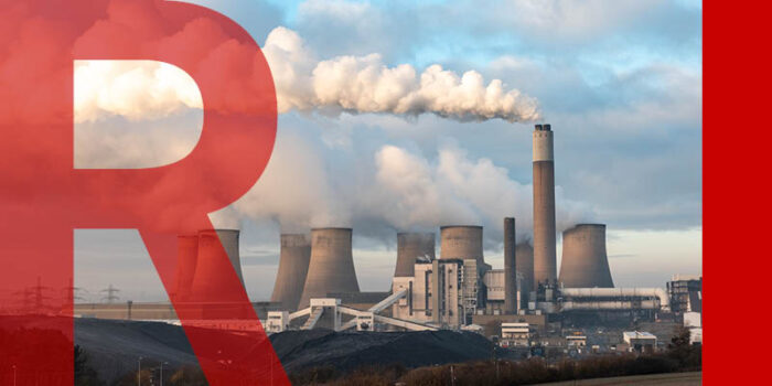 A large coal power station emitting clouds of smoke into the air.