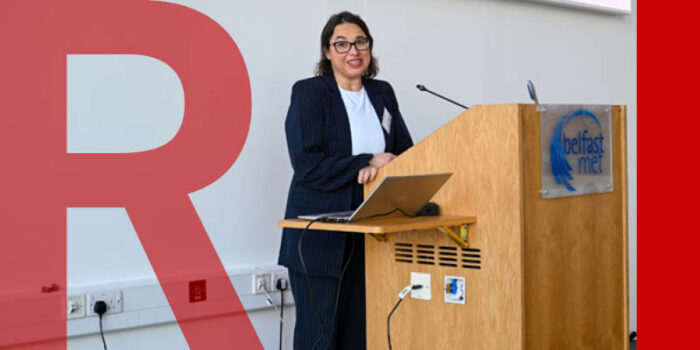 Ana Manzano wearing a suit standing behind a lectern